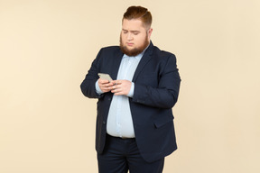 Young overweight office worker checking phone