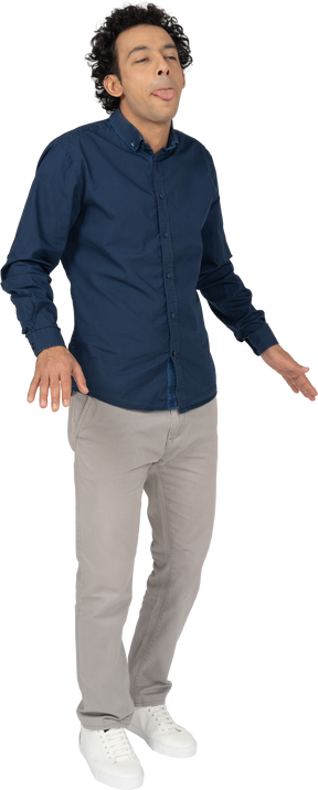 Vista frontal de um homem com roupas casuais mostrando a língua