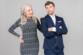 Old woman leaning hand on her young boyfriend's back