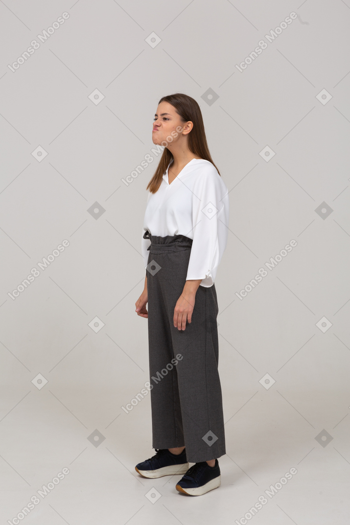 Three-quarter view of a grimacing young lady in office clothing