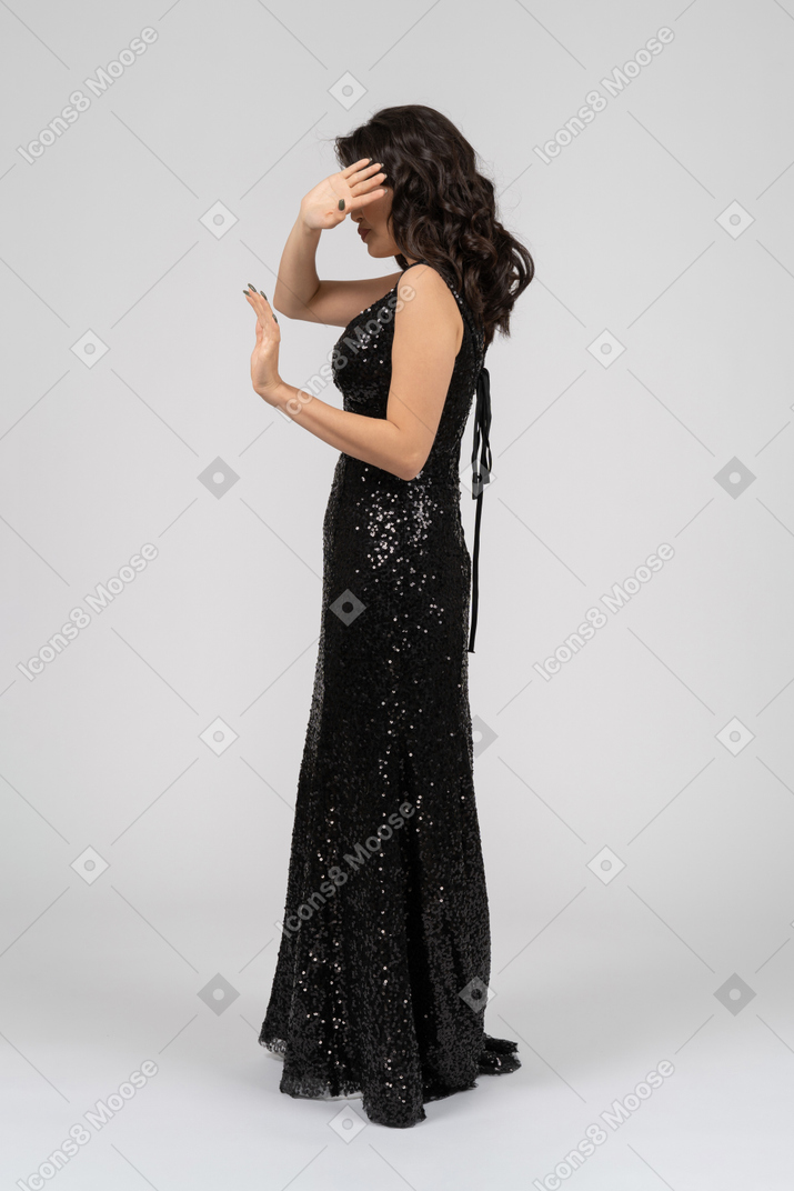 Woman in black evening dress hiding face