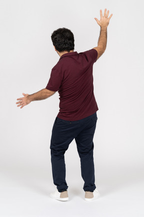 Back view of man raising arms