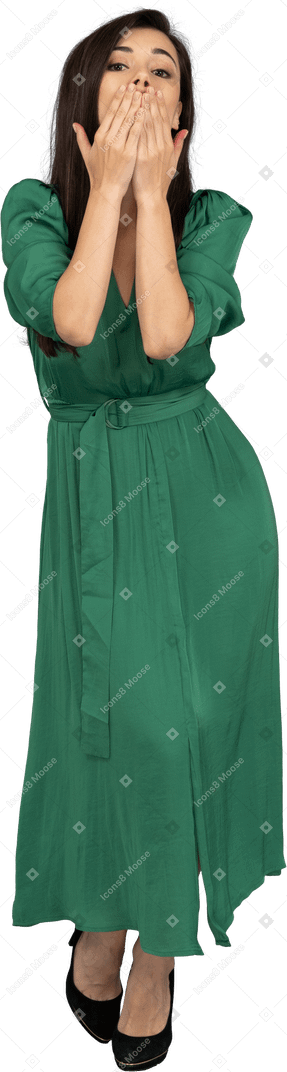 Вид спереди молодой леди в зеленом платье, посылающей воздушный поцелуй