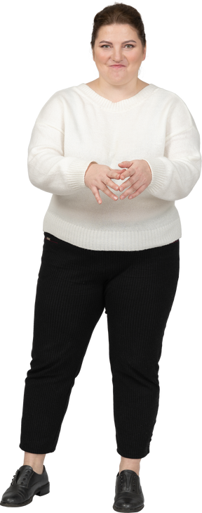 Женщина больших размеров в белом свитере смотрит в камеру