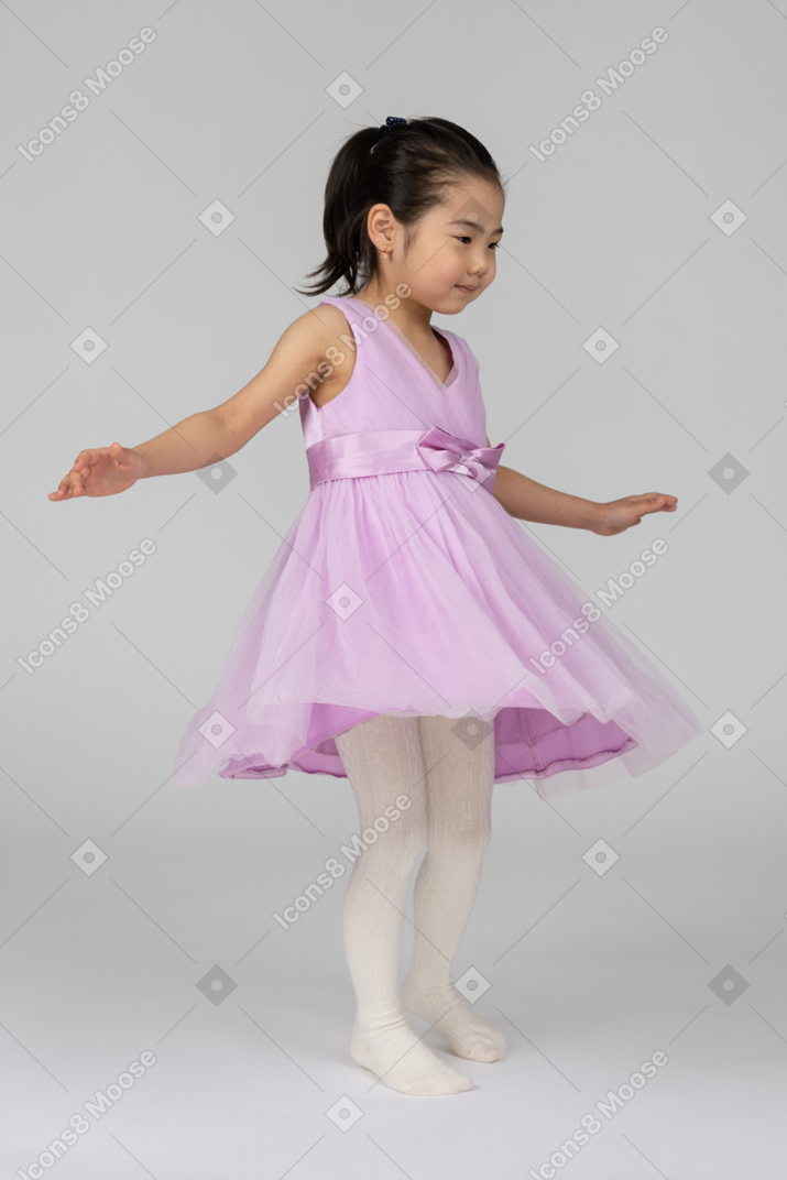 Menina de vestido rosa dançando