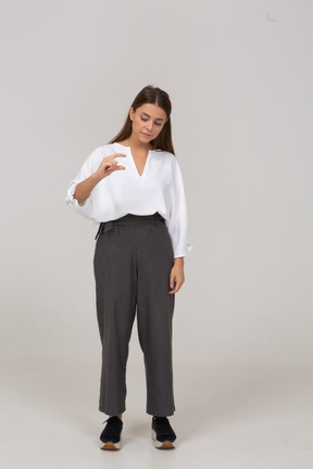 Vista frontal de una joven en ropa de oficina que muestra el tamaño de algo