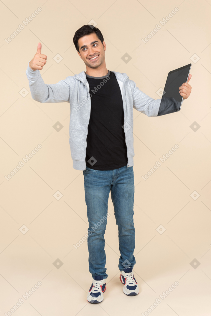 Молодой кавказский мужчина держит цифровой планшет