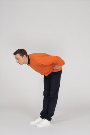 Young man in orange sweatshirt posing