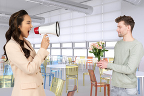 Woman yelling at man through megaphone