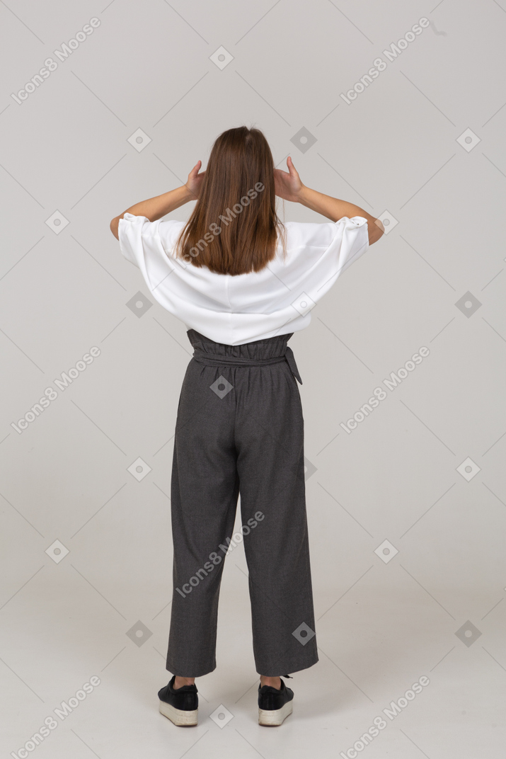 Back view of a young lady in office clothing shutting her eyes