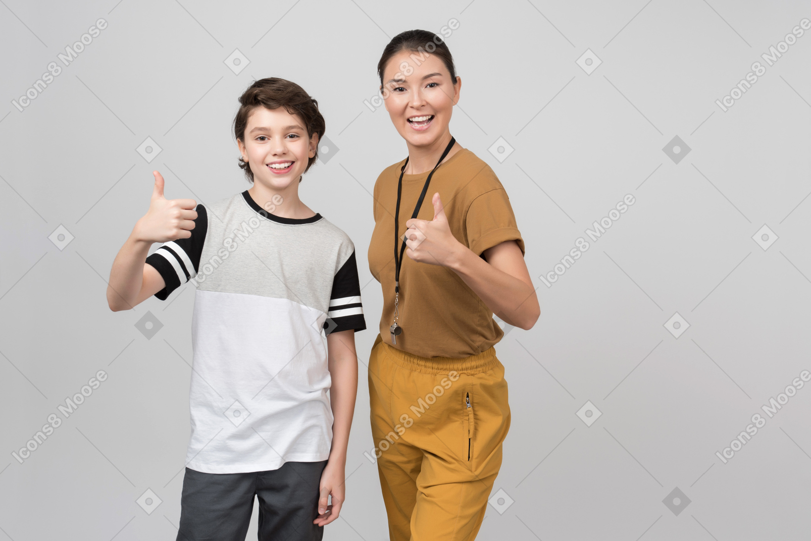 Pe female teacher and pupil smiling and showing thumbs up