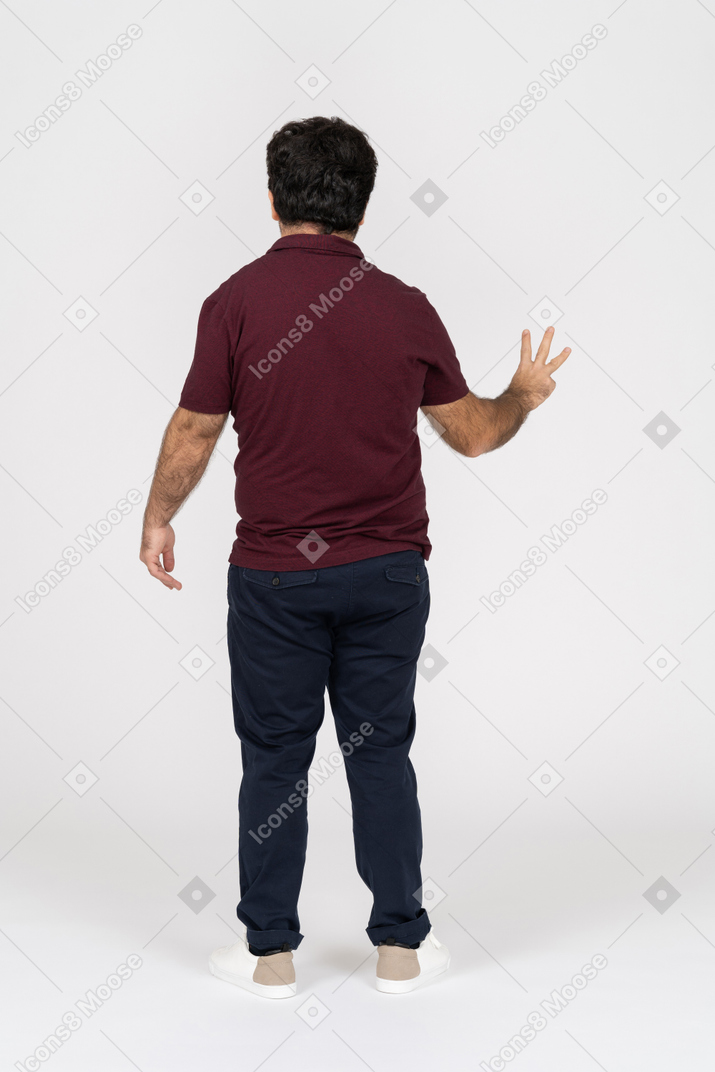 Vista traseira do homem mostrando três dedos