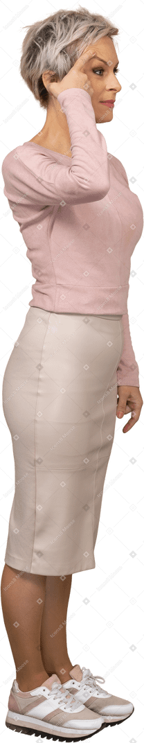 Vista lateral de uma mulher com roupas casuais tocando a sobrancelha com o dedo