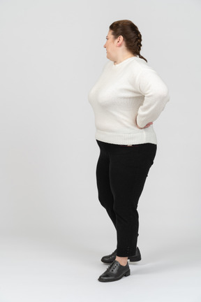 Plump woman in casual clothes standing with hands on hips