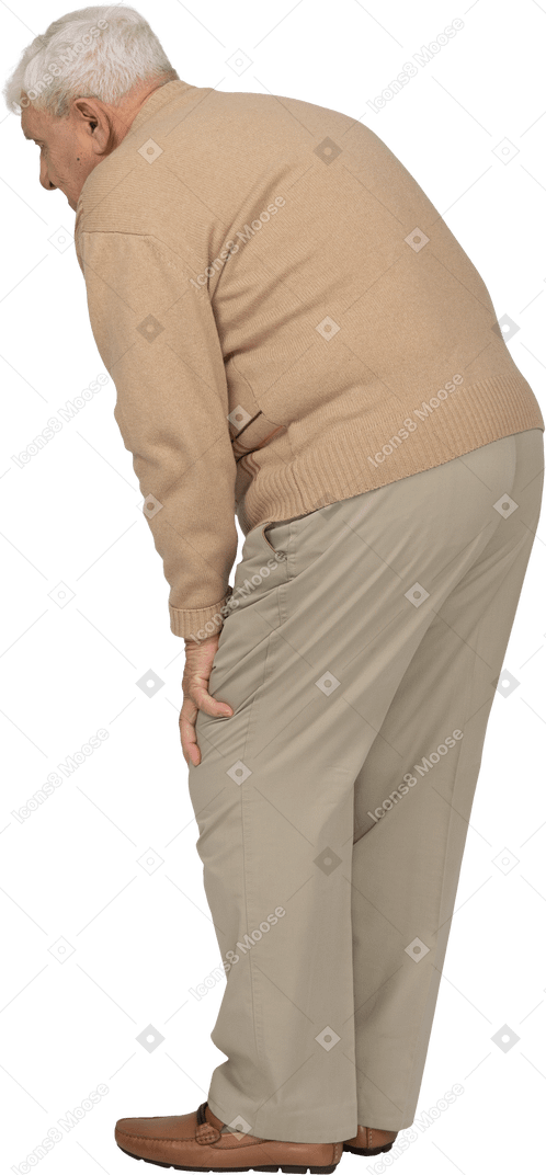 Side view of an old man bending down and touching his hurting knees