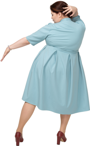 Rear view of a woman in blue dress dancing