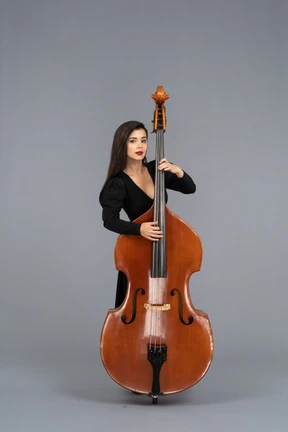 Vista frontal, de, un, mujer joven, en, vestido negro, juego, ella, contrabajo