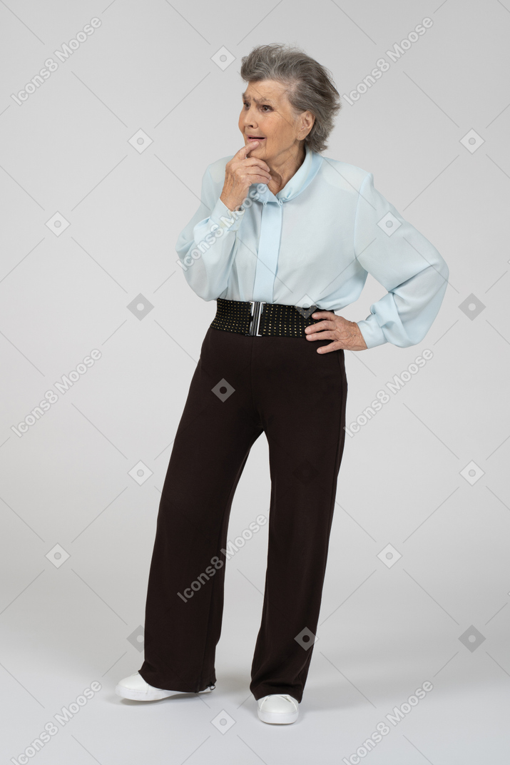 Vista frontal de una anciana tocando la barbilla con incertidumbre