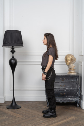 Side view of a young female rocker standing in a room