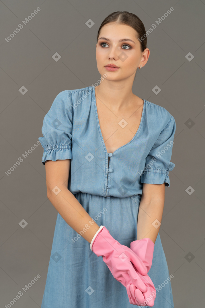 Young woman holding her own hand while wearing pink gloves