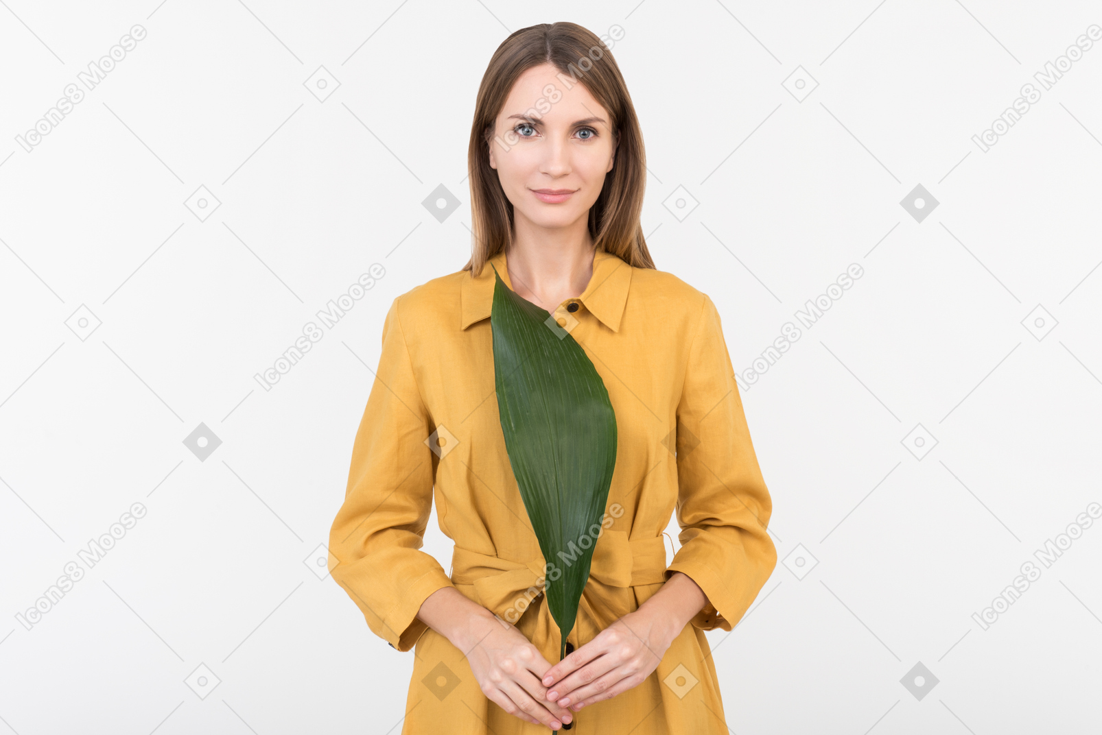 緑の葉を保持している若い女性