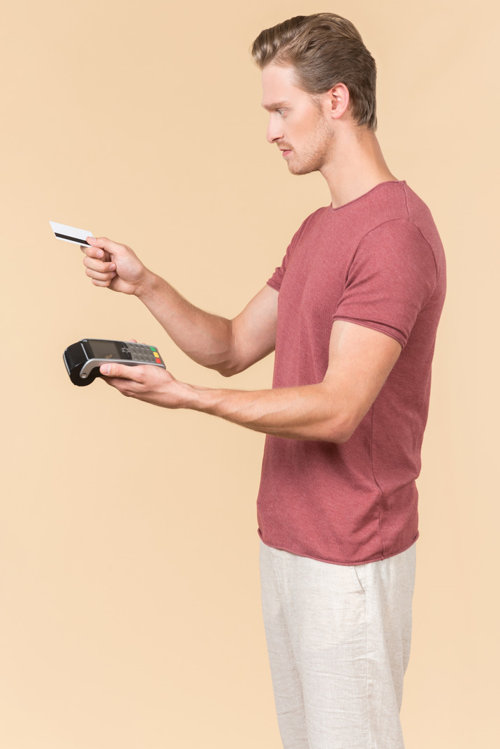 Young guy using a payment terminal