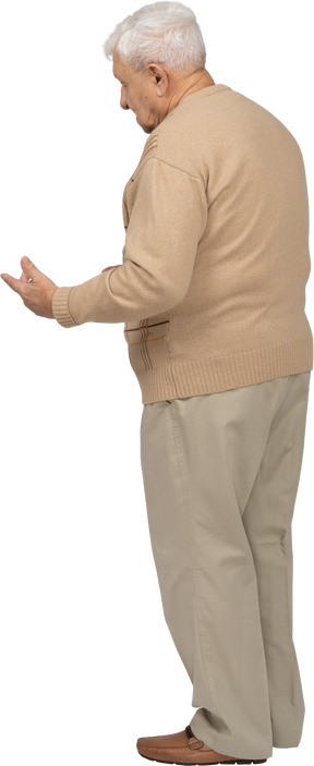 Side view of an old man in casual clothes explaining something