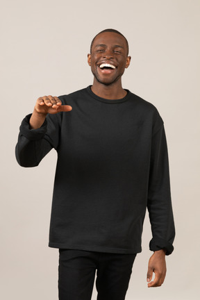 Young man laughing with hand up