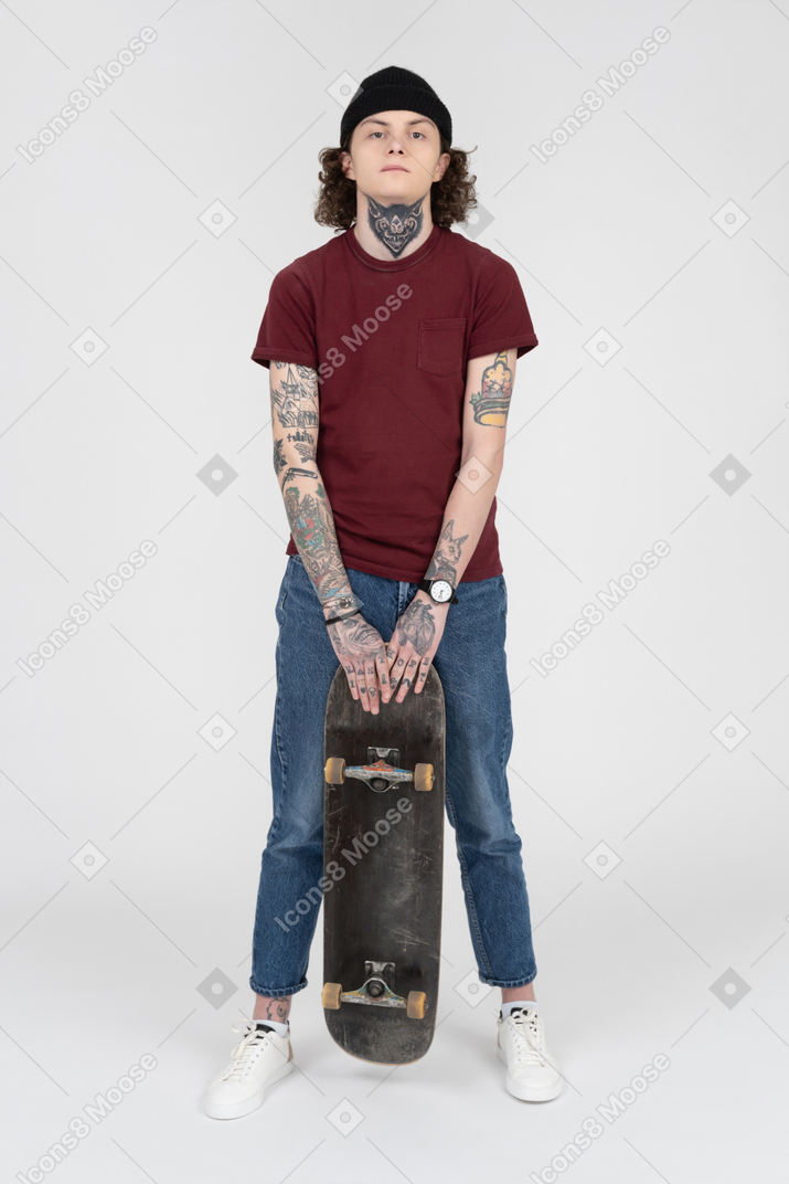 Un adolescente in piedi con il suo skateboard
