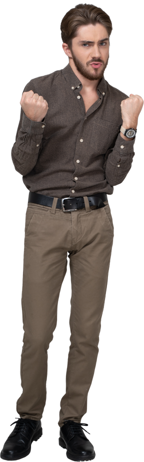 Vista frontal de um jovem sério com roupas de escritório cerrando os punhos