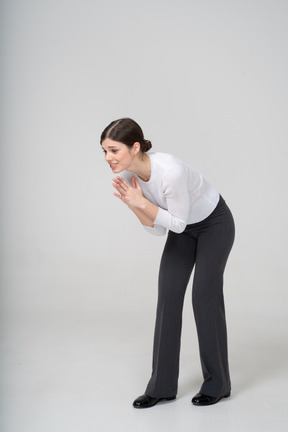 Vista frontal de una mujer en traje haciendo gesto de oración