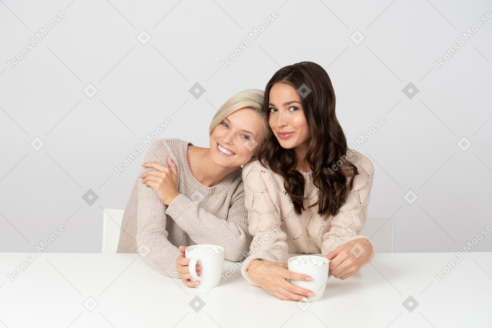 Women embracing and drinking coffee