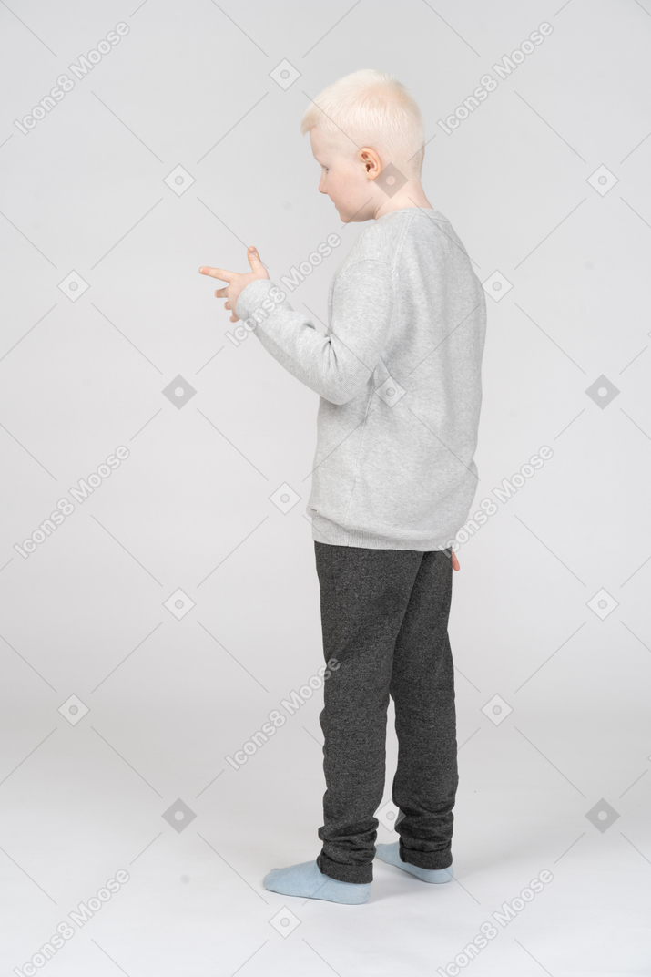 Little boy standing with a hand gesture