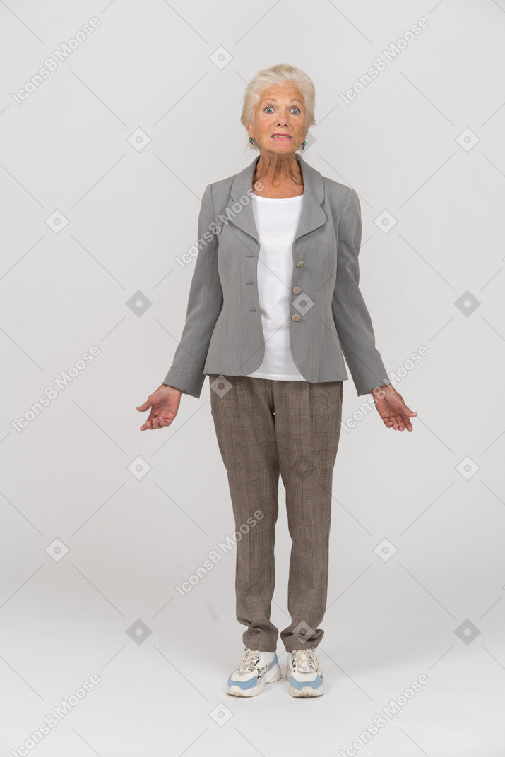 Vista frontal de una anciana en chaqueta gris mirando a la cámara