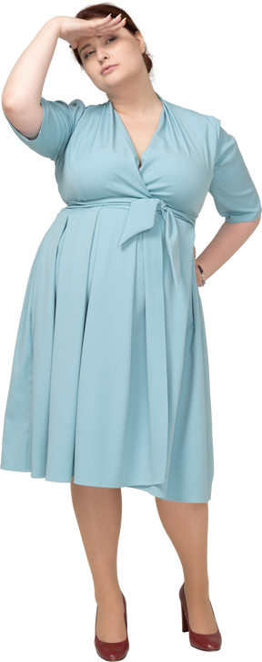 Vista frontale di una donna in abito blu che cerca qualcuno