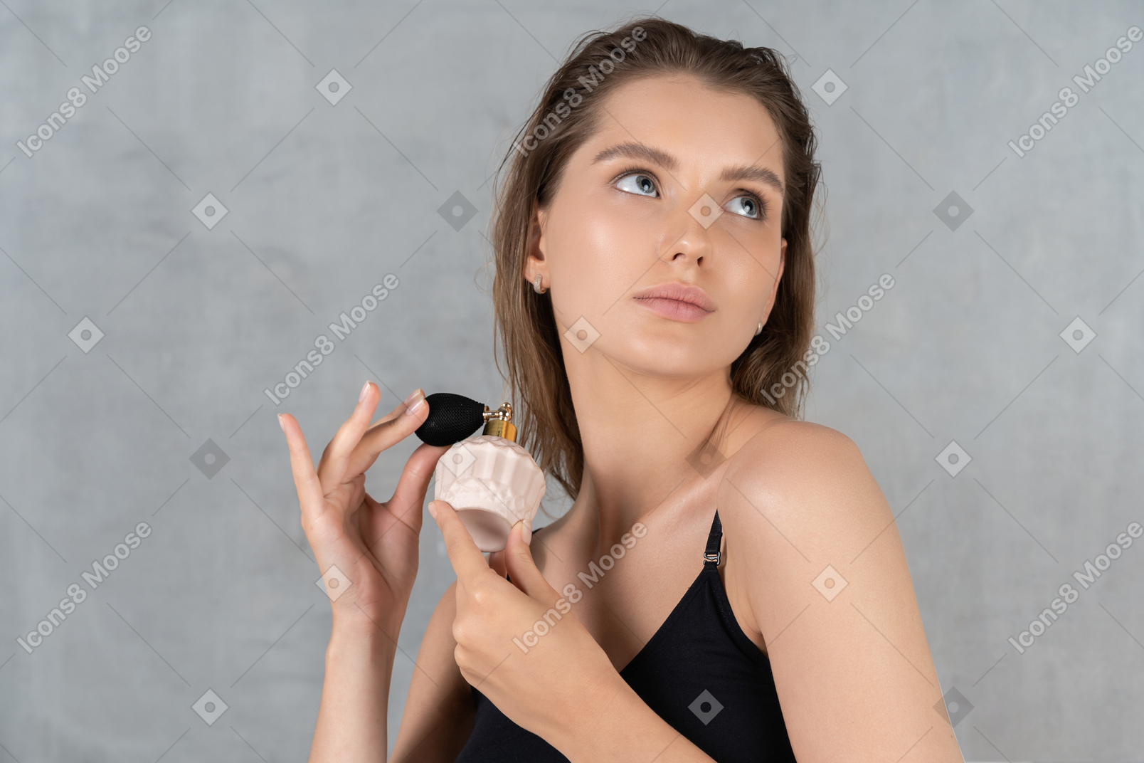 Close-up of a young woman putting on perfume