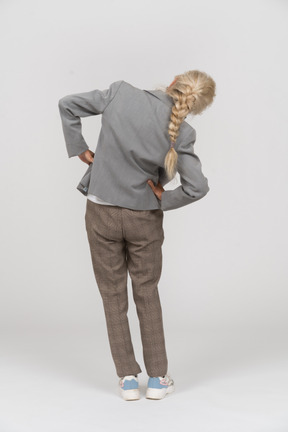 エクササイズをしているスーツの老婦人の背面図