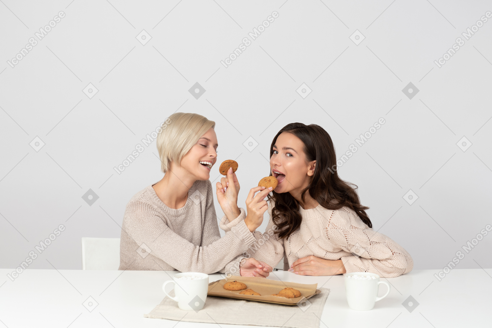お互いにクッキーを食べさせる若い女性