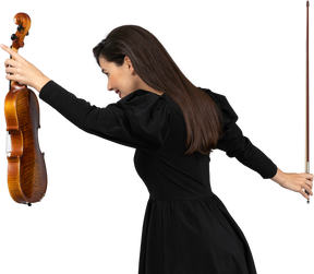 Vista posteriore di tre quarti di una suonatrice di violino in abito nero che fa un inchino
