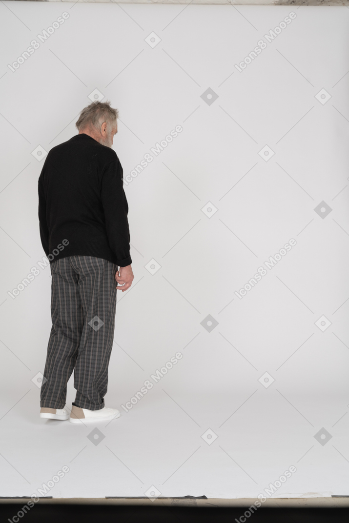 Anciano parado de espaldas a la cámara