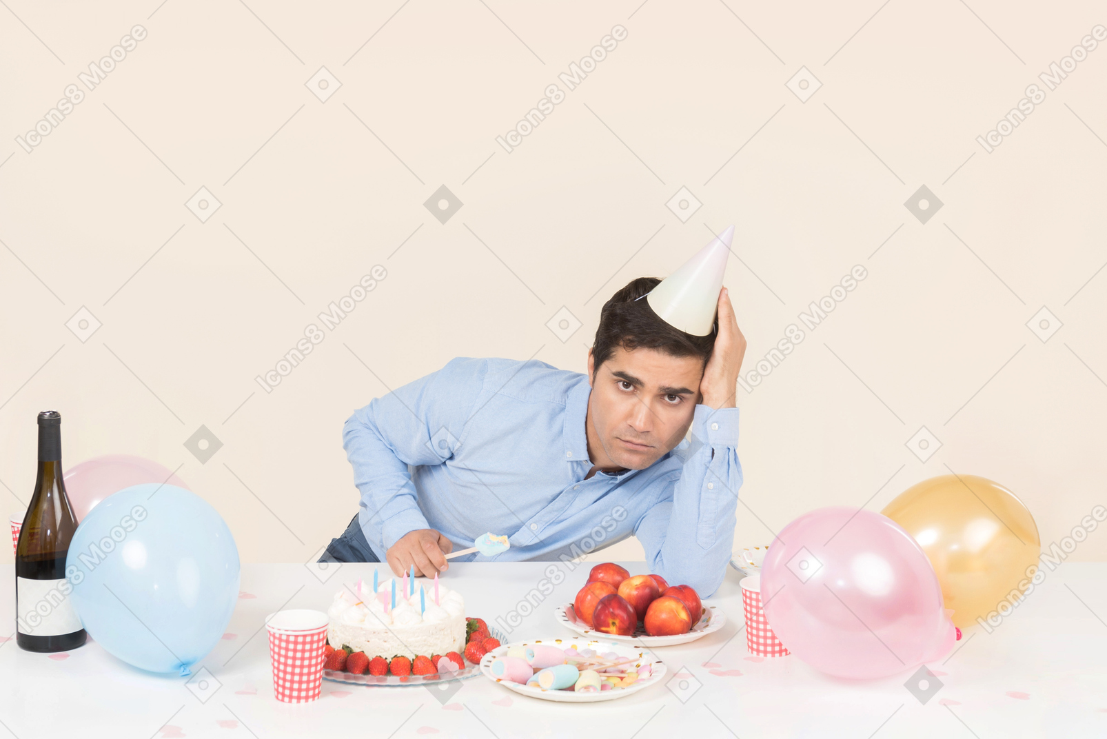 Sad looking young man sitting at birthday table