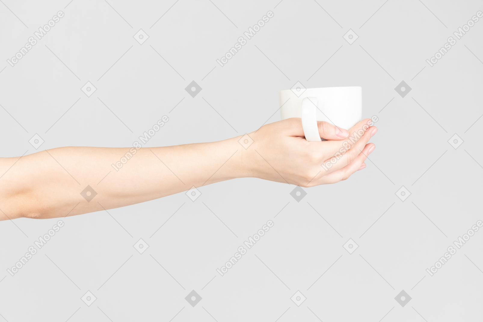 Mano femminile che tiene tazza di ceramica bianca