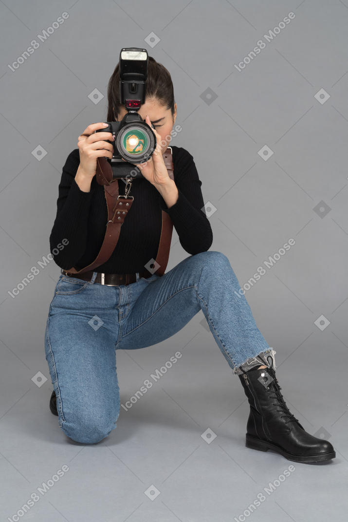 Young woman getting down on her knees to take pictures