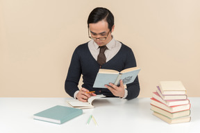 Young asian student in a sweater reading a book