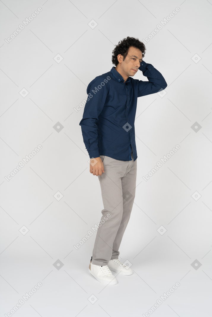 Вид сбоку на человека в повседневной одежде, стоящего с рукой за головой