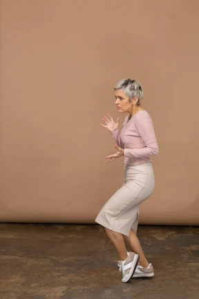 Scared woman in casual clothes posing in profile