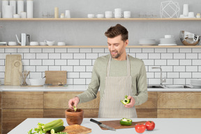 A man in a kitchen preparing food on a cutting board