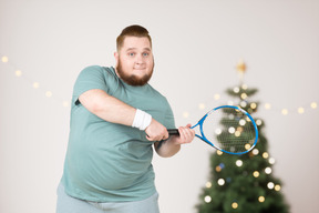 Fat guy is happy to get a tennis racket for christmas