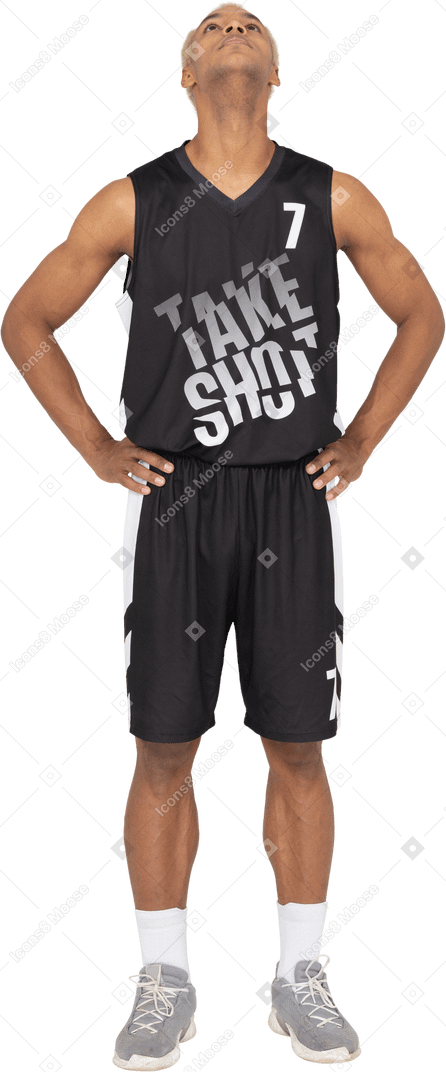 Vue de face d'un jeune joueur de basket-ball masculin mettant les mains sur les hanches et levant les yeux