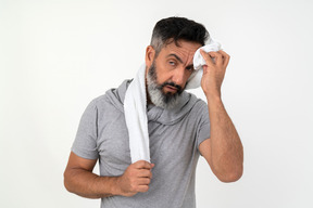 Mature man wiping sweat with the towel